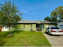 Charming single-story home features a well-maintained lawn and a private driveway at 2016 Woodward Ave, Dunedin, FL 34698