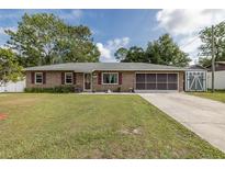 Charming single-story brick home with well-maintained lawn and covered garage at 27263 Warner Ave, Brooksville, FL 34602