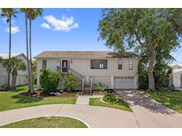 Charming two-story home with landscaped yard and a circular driveway on a sunny day at 4048 Bluefish Dr, Hernando Beach, FL 34607