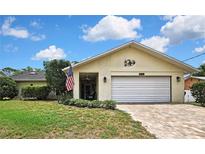 Charming single-story home with a brick driveway, American flag, and well-maintained landscaping at 4072 Everett Ave, Spring Hill, FL 34609
