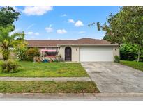 Charming single-story home with a well-manicured front yard and attached two car garage at 4350 Sawgrass Blvd, New Port Richey, FL 34653