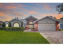 Charming home with manicured lawn, brick accents, arched windows and paved driveway at 5249 Wellfield Rd, New Port Richey, FL 34655