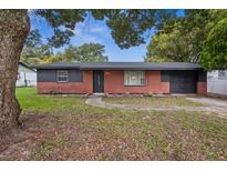 Charming single-story home features a brick facade, dark trim, and a well-maintained lawn at 5323 23Rd St, Zephyrhills, FL 33542