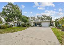 Charming single-story home featuring a long driveway, well-maintained landscaping, and an attached one-car garage at 6046 River Rd, New Port Richey, FL 34652