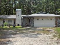 Ranch home with stone accents, gray roof and a two car garage in a treed neighborhood at 7239 Lykes Dublin Rd, Brooksville, FL 34601