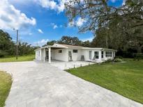 Charming single-story home with a well-manicured lawn and a paved driveway under a sunny sky at 8540 Roseanne Blvd, New Port Richey, FL 34654