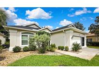 Charming single-story home showcasing manicured landscaping and a welcoming front entrance on a sunny day at 10093 Holly Berry Dr, Weeki Wachee, FL 34613