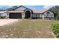 Well-maintained single-story home with a two-car garage and drought resistant landscaping at 10244 Hoover St, Spring Hill, FL 34608