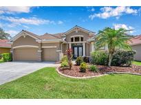 Charming home with a two-car garage, beautiful landscaping, and inviting entrance at 11726 Belle Haven Dr, New Port Richey, FL 34654