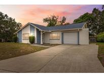 Charming single Gathering home with a well maintained front lawn and a private driveway at 13001 Sawmill Way, Hudson, FL 34667