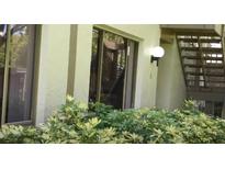 Exterior angle of condo showing windows, lighting fixture, greenery, and stairs at 13010 Wedgewood Way # A, Hudson, FL 34667