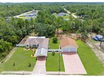 Expansive aerial view of home showcasing the spacious lot, detached garage, and proximity to surrounding trees at 13444 English Parrot Rd, Brooksville, FL 34614