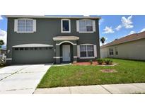 Two-story home featuring an attached two-car garage, arched entryway, and verdant lawn at 15160 Durango Cir, Brooksville, FL 34604
