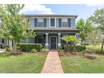 Inviting two-story home featuring a lush landscaped front yard and covered entryway at 17316 Cruiser Bnd, Land O Lakes, FL 34638