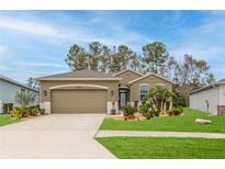 Beautiful single-story home with a well-manicured lawn and a two-car garage at 17679 Garsalaso Cir, Brooksville, FL 34604