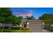 Charming single-Gathering home featuring a well-maintained lawn, mature trees, and neutral exterior paint at dusk at 17843 Garsalaso Cir, Brooksville, FL 34604