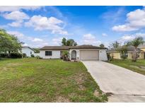 Charming single-story home featuring a well-maintained lawn and attached garage at 2450 Ambassador Ave, Spring Hill, FL 34609