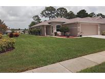 Charming single-story home with a well-manicured lawn and landscaping at 2930 Plantain Dr, Holiday, FL 34691