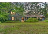 Charming home with a cozy front porch, beautiful landscaping, and a lush green lawn at 3270 Endsley Rd, Brooksville, FL 34604