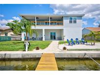 Waterfront home boasts a covered patio, walk-out access to the beach, dock, and serene water views at 4469 Bahama Dr, Hernando Beach, FL 34607