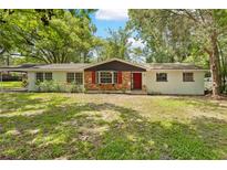 Charming single-story home with brick accents, a red front door, and a well-maintained lawn at 507 Jewel St, Brooksville, FL 34601