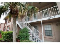 Building 1 shows a exterior stairway, tropical landscaping, and neutral paint at 6338 Spring Flower Dr # 21, New Port Richey, FL 34653