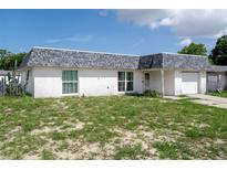 Single-story home featuring a gray shingle roof, stucco walls, and a one-car garage at 7608 Dale Dr, Port Richey, FL 34668