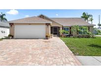 Charming single-story home featuring a brick driveway and attached two-car garage at 7923 Woburn St, New Port Richey, FL 34653