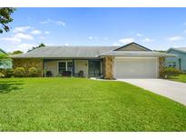 Charming single-story home with stone accents, a well-manicured lawn, and an attached two-car garage at 8213 Valley Stream Ln, Hudson, FL 34667