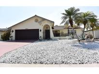 Charming single-story home features decorative stucco work, desert landscaping, and a two car garage at 9003 Lido Ln, Port Richey, FL 34668