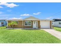 Charming single-story home with a well-manicured lawn and a cozy, covered front porch, inviting curb appeal at 9016 Unicorn Ave, Port Richey, FL 34668