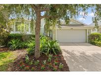 Charming single-story home with lush landscaping and a two-car garage and beautiful front yard at 1010 Teal Pointe, Tarpon Springs, FL 34689