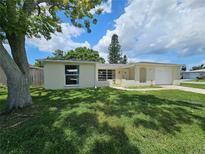 Charming single-story home with a well-manicured lawn and attached garage at 10135 Glen Moor Ln, Port Richey, FL 34668