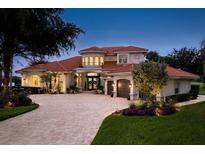 Beautiful two-story home featuring a red tile roof, a brick driveway, and lush landscaping at 10342 Altrara Way, Trinity, FL 34655