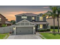 Charming two-story home featuring a well-manicured lawn and an attached two-car garage at 1104 Ketzal Dr, Trinity, FL 34655