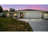 Charming single-story home featuring a welcoming arched entryway and an attached two-car garage at 11280 Sedgefield Ave, Spring Hill, FL 34608