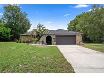 Charming single-story home with stone accents, well-manicured lawn, and a convenient two-car garage at 1376 Fayetteville Dr, Spring Hill, FL 34609