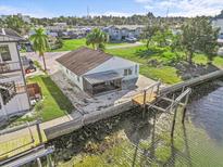 Waterfront home featuring a private dock with boat lift access to beautiful canal and lush landscaping at 13821 Judy Ave, Hudson, FL 34667