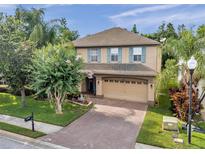 Charming two-story home featuring a brick driveway, well-maintained landscaping, and a two-car garage at 1410 Halapa Way, Trinity, FL 34655