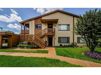 Inviting two-story condo with well-maintained lawn and wood staircase leading to the entrance at 3841 Lanyard Ct # B, New Port Richey, FL 34652