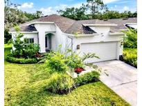 Charming single-story home boasting a two-car garage, manicured lawn, and lush landscaping at 4082 Watson Dr, New Port Richey, FL 34655
