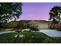 Charming single-story home featuring a well-manicured lawn, mature trees, and a two-car garage at 4269 River Birch Dr, Spring Hill, FL 34607