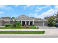 Charming one-story home with a manicured lawn, colorful flower beds, and a spacious three-car garage at 4287 Woodland Retreat Blvd, New Port Richey, FL 34655