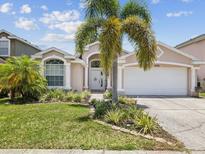 Charming single-story home featuring a well-manicured lawn and a two-car garage at 4716 Wolfram Ln, New Port Richey, FL 34653