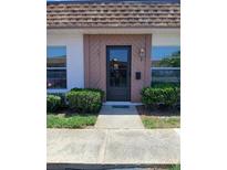 Inviting entryway with a storm door, well maintained landscaping, and clear house number at 6050 Chesham Dr # 3, New Port Richey, FL 34653