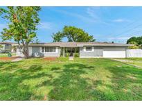 Charming single-story home with a well-manicured lawn, mature trees, and an attached garage at 6795 23Rd S St, St Petersburg, FL 33712