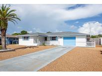 Charming home with a white exterior, blue shutters, a light blue garage door, and low maintenance landscaping at 10123 Oak Hill Dr, Port Richey, FL 34668