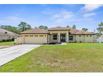 Charming single-story home featuring a well-manicured lawn and an attached two-car garage at 12026 Penguin Ave, Weeki Wachee, FL 34614
