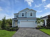 Charming two-story home with a paver driveway, attached two-car garage and inviting blue exterior at 14425 Maiden Ter, Lakewood Ranch, FL 34211