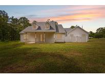 Beautiful white home with a spacious front yard and covered porch, perfect for enjoying sunsets at 2288 Rackley Rd, Brooksville, FL 34604